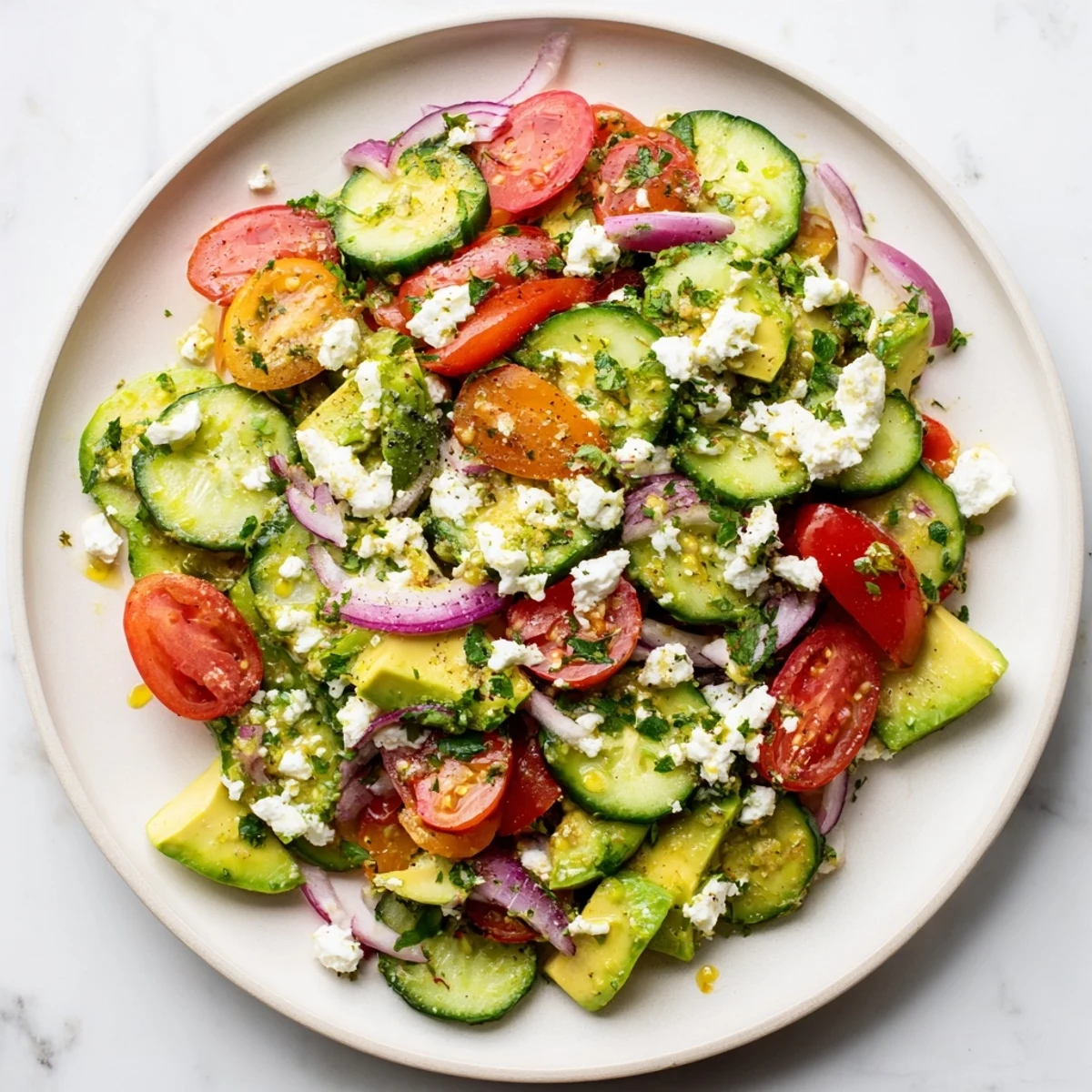 Bright, colorful Fresh Salad with tomatoes, cucumber, avocado, and feta, ready to eat.