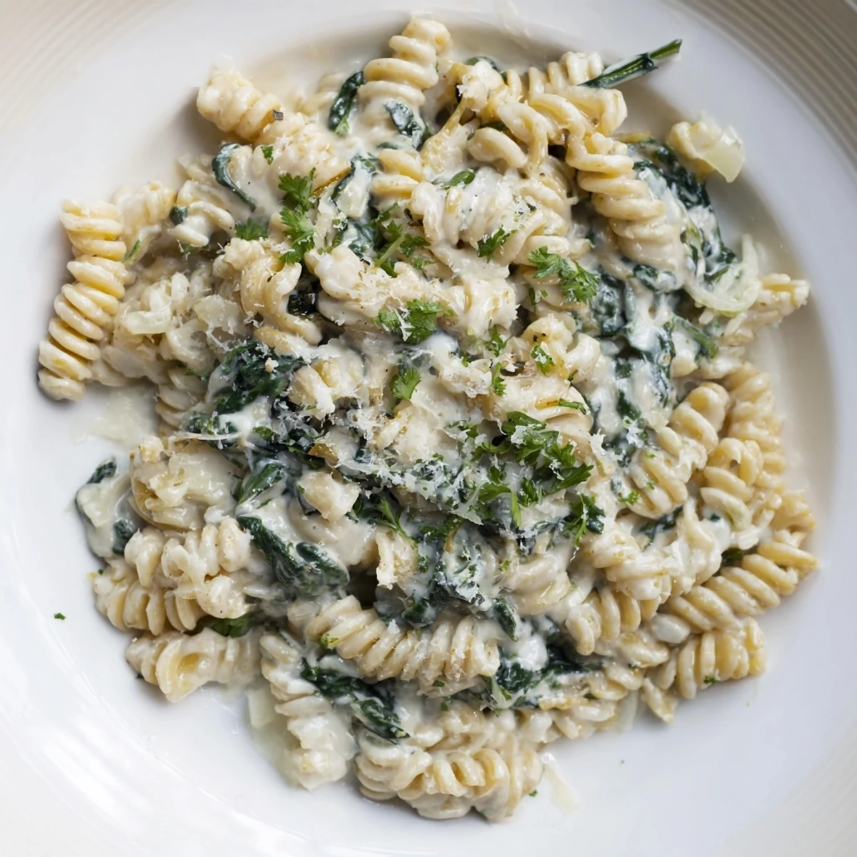 A steaming bowl of The Magic Casserole: Creamy Spinach Pasta, with bubbly cheese and fresh parsley.