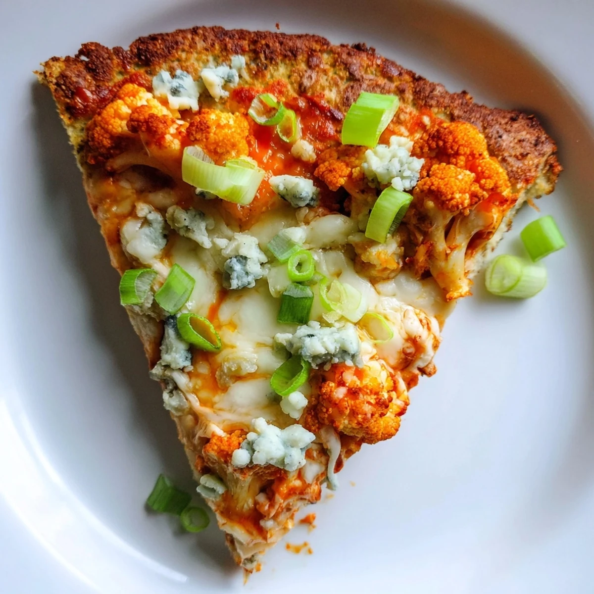 A close-up of a cheesy Buffalo Cauliflower Pizza with bubbly crust and fresh parsley garnish, perfect for game day.