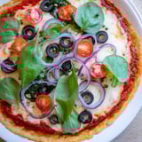 A close-up of a perfectly baked Crispy Tortilla Pizza, ready for slicing and enjoying.