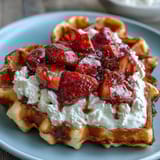 Heart-shaped waffles topped with creamy cottage cheese whip and fresh strawberries, perfect for a romantic breakfast or brunch.