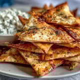 Crispy homemade pita chips with cool, creamy tzatziki — perfect for dipping at your next summer gathering.