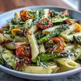 Colorful spring pasta primavera with fresh veggies, showcasing tender penne and vibrant seasonal vegetables in a light, herby sauce.