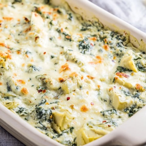 Warm Spinach and Artichoke Dip, bubbly and golden, ready and inviting with toasted baguette slices.