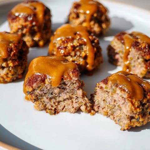 Mini meatloaf bites glistening with a sweet, tangy glaze, perfect for a cozy weeknight meal.