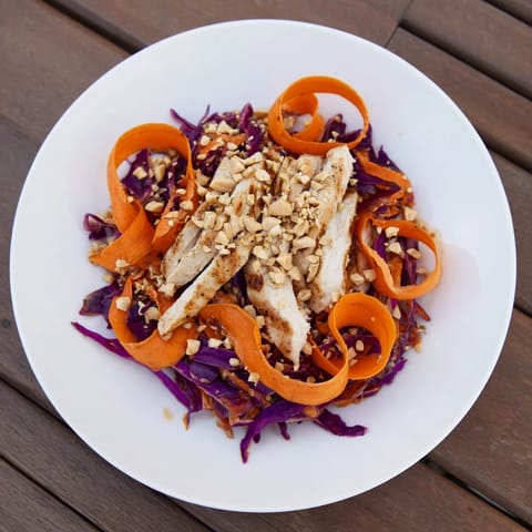 Enjoy tender chicken nestled in a crunchy heap of Carrot Ribbon and Chicken Slaw with peanuts.