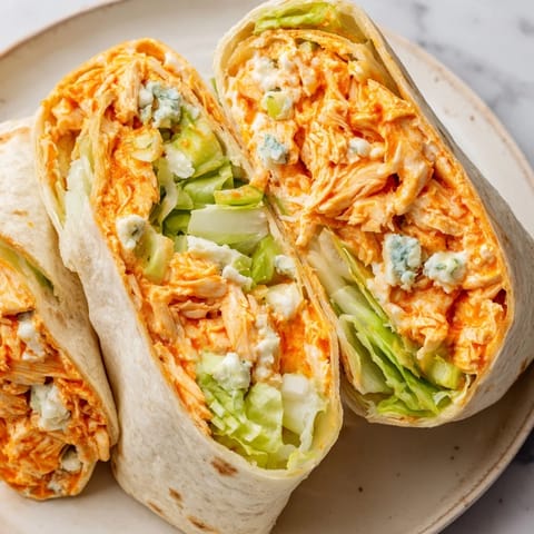 Golden-brown Buffalo Chicken Dip Wrap slices reveal savory, cheesy filling perfect for lunch or game day.
