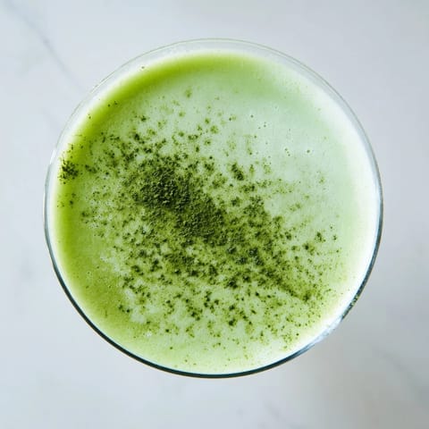 The vibrant green Matcha Martini cocktail combines earthy matcha, vodka, and cream for a creamy, chilled drink.