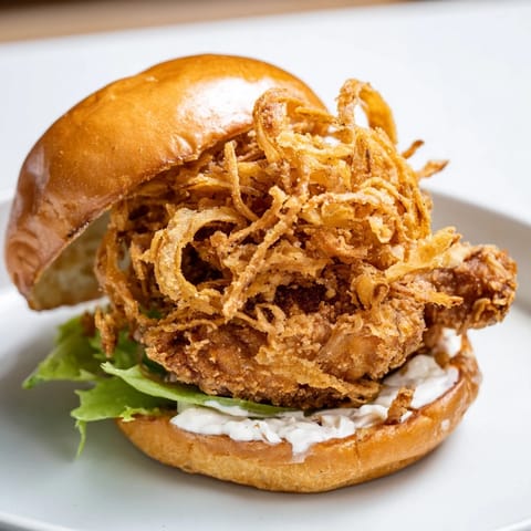 Crispy Onion Chicken Sandwich served on a soft bun with crunchy fried onions and fresh lettuce.