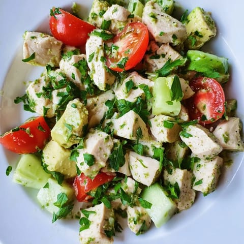 Colorful Avocado Chicken Salad served in a rustic bowl, garnished with fresh cilantro and parsley, ready for a light lunch or picnic.  