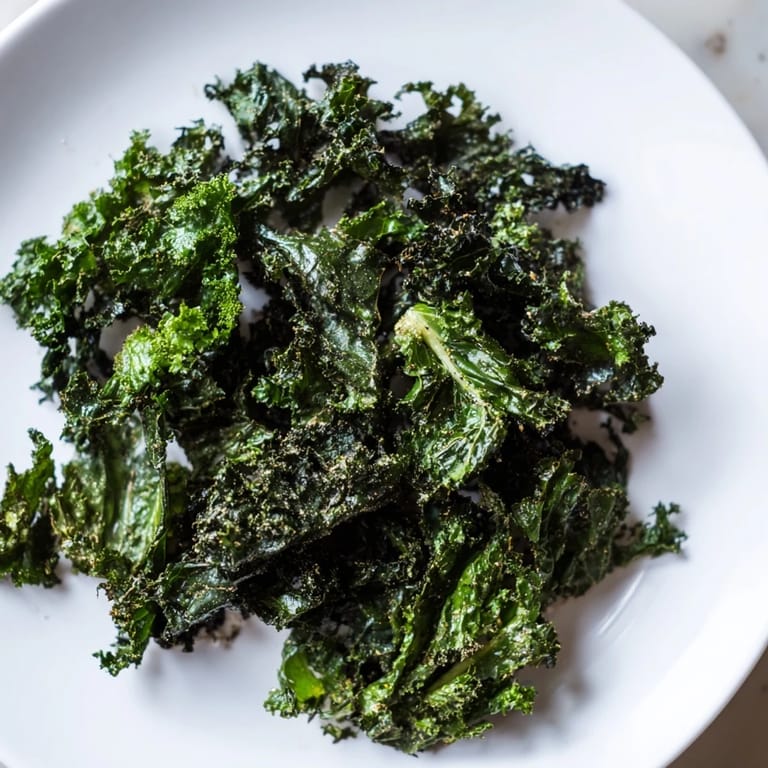Freshly prepared, crispy kale chips, seasoned and ready to eat, a quick and delicious American snack.