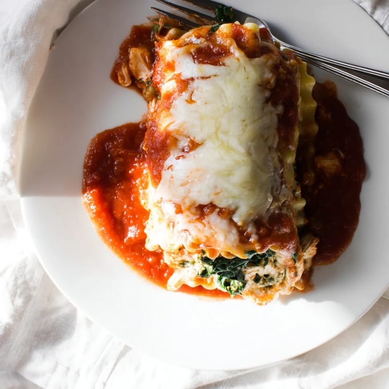 Serving suggestion for Chicken and Spinach Lasagna Rolls, plated with fresh parsley and a side of green salad.