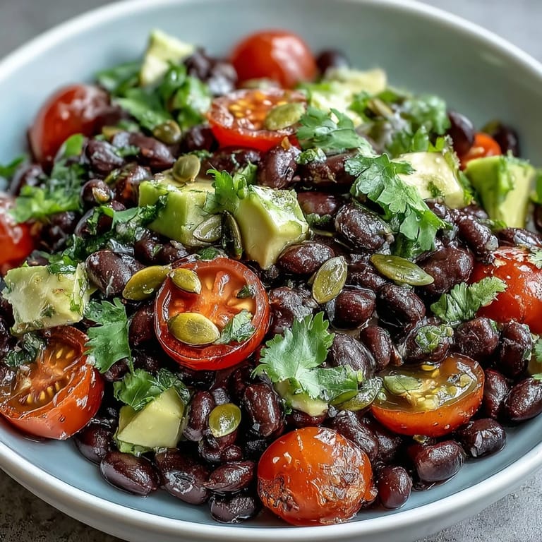 Fresh cilantro and black beans shine in this nourishing veggie bowl, topped with crunchy pumpkin seeds and diced avocado.  