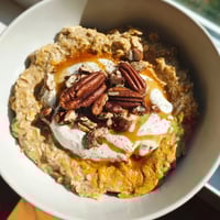 Warm Pumpkin Spice Latte Oats, creamy breakfast topped with whipped cream and pecans.