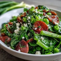 Vibrant spring salad with lemon vinaigrette, radishes, and peas in a white bowl.